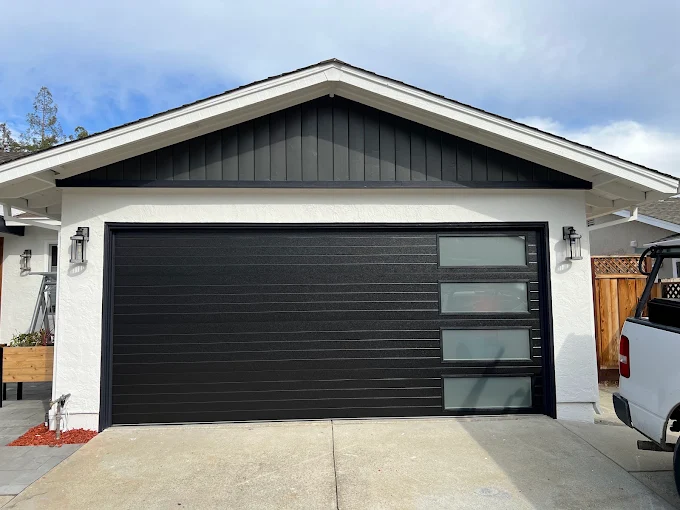 Modern black horizontal-panel garage door with frosted glass windows